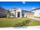 Two-story house exterior with stone accents, paver driveway and landscaping at 686 Creeping Fig St, Apopka, FL 32703