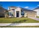 Two-story house exterior with stone accents, paver driveway and landscaping at 686 Creeping Fig St, Apopka, FL 32703