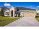 Two-story house exterior with stone accents, paver driveway and landscaping at 686 Creeping Fig St, Apopka, FL 32703