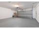 Spacious garage with an open garage door and freshly painted floor at 13655 Podocarpus Ln, Orlando, FL 32828