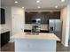 Modern kitchen featuring dark wood cabinetry, stainless steel appliances, and a center island with a sink at 247 Villavista Ct, Davenport, FL 33896