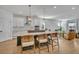 Stylish kitchen featuring an island with bar seating, white cabinets and hardwood floors at 4473 Davos Dr, Clermont, FL 34711