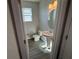This half bathroom features a pedestal sink, gray tile floors, and a modern light fixture at 576 Pothos St, Apopka, FL 32703