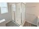 Modern glass enclosed shower with white subway tile and grey tiled floors at 576 Pothos St, Apopka, FL 32703