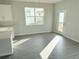Cozy dining area with gray tile flooring next to a kitchen with white countertops and a sunny window at 576 Pothos St, Apopka, FL 32703