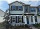 Charming two-story townhome with a combination of white stone and muted green siding, accented by black shutters at 576 Pothos St, Apopka, FL 32703