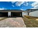 New construction home with open garage, brick paver driveway, and well manicured lawn at 576 Pothos St, Apopka, FL 32703