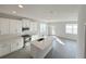 Open kitchen with stainless appliances, white cabinets, tile floors, island with sink and views to living area at 576 Pothos St, Apopka, FL 32703