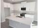 Bright kitchen featuring white cabinets, stainless steel appliances, and a large center island with sink and counter space at 576 Pothos St, Apopka, FL 32703