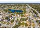 An aerial view of a neighborhood showcasing a scenic pond, tree coverage, and nearby roadways at 9517 Brackin St, Orlando, FL 32825