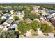 Aerial view of home nestled among mature trees and landscaping in a quiet residential neighborhood near a lake at 9517 Brackin St, Orlando, FL 32825