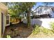 A backyard with a concrete patio, grill, wooden fence, and large shade tree at 9517 Brackin St, Orlando, FL 32825
