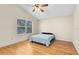 Bright bedroom features a ceiling fan, hardwood floors, and natural light through a large window at 9517 Brackin St, Orlando, FL 32825