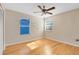 Bright bedroom with hardwood floors, a ceiling fan, and plenty of natural light from two large windows at 9517 Brackin St, Orlando, FL 32825