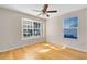 Light-filled bedroom with hardwood floors and a ceiling fan, with two windows for ample natural light at 9517 Brackin St, Orlando, FL 32825