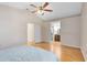 Spacious main bedroom with hardwood floors, ceiling fan, and ensuite bathroom and closet access at 9517 Brackin St, Orlando, FL 32825