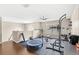 Second floor exercise room with work out equipment, dark wood floors and a ceiling fan at 800 Daybreak Dr, Fruitland Park, FL 34731