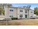 Two-story home with trimmed windows, solar panels, a green door, and front yard landscaping at 800 Daybreak Dr, Fruitland Park, FL 34731