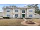 Two-story home featuring a green door, trimmed windows, solar panels, and front yard landscaping at 800 Daybreak Dr, Fruitland Park, FL 34731