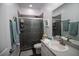 A modern bathroom features a glass-enclosed shower, sleek fixtures, and stylish gray accents at 881 Orchid Grove Blvd, Davenport, FL 33837