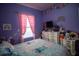 Colorful bedroom featuring a bed with patterned linens and bright rainbow decorations at 881 Orchid Grove Blvd, Davenport, FL 33837