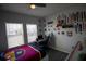A cozy bedroom features a large window with natural light, gray wood floors, and personal touches on the wall at 881 Orchid Grove Blvd, Davenport, FL 33837