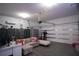 Spacious garage featuring a sectional sofa, mounted air conditioner, and work-out equipment at 881 Orchid Grove Blvd, Davenport, FL 33837