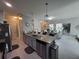 An open-concept kitchen features stainless steel appliances, an island with granite countertops, and modern pendant lighting at 881 Orchid Grove Blvd, Davenport, FL 33837