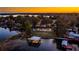Aerial view of lakefront property at sunset featuring a dock and boat house at 647 Ridgewood Dr, Windermere, FL 34786
