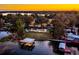 Aerial view of lakefront property with lush greenery, private dock, and beautiful home at sunset at 647 Ridgewood Dr, Windermere, FL 34786