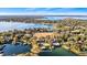 Aerial view of the lakefront property with mature trees, private dock, boat house, and surrounding landscape at 647 Ridgewood Dr, Windermere, FL 34786