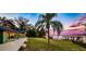 Lush backyard with mature landscaping, wooden deck, and private dock on the water at 647 Ridgewood Dr, Windermere, FL 34786