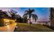 Spacious backyard with large lawn, mature trees, and a dock overlooking the serene lake at 647 Ridgewood Dr, Windermere, FL 34786