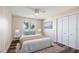 Bright bedroom with a queen bed, ceiling fan, large window with water view, and closet at 647 Ridgewood Dr, Windermere, FL 34786