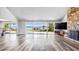 Open concept living room with a stone fireplace and multiple sliding glass doors overlooking the lake at 647 Ridgewood Dr, Windermere, FL 34786
