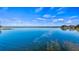 Beautiful waterfront view with a calm lake reflecting the blue sky and a small amount of vegetation at 647 Ridgewood Dr, Windermere, FL 34786