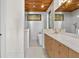 Modern bathroom with double vanity, wood ceiling, tiled walls, soaking tub, and brass fixtures at 1340 Susannah Blvd, Orlando, FL 32803
