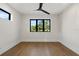 Spacious bedroom with wood floors, white walls, and a large black-framed window at 1340 Susannah Blvd, Orlando, FL 32803