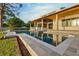 A stunning pool and outdoor living space featuring covered patio with wood beams and neutral stone at 1340 Susannah Blvd, Orlando, FL 32803