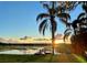 Waterfront view featuring a dock and scenic sunset over the tranquil lake at 1340 Susannah Blvd, Orlando, FL 32803