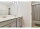 Modern bathroom with dual sinks, gray cabinets, and a shower at 1402 Olympic Club Blvd, Champions Gate, FL 33896