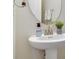 Elegant powder room with pedestal sink and oval mirror at 1402 Olympic Club Blvd, Champions Gate, FL 33896