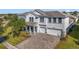 Two-story house with gray exterior, three-car garage, and a paved driveway at 1402 Olympic Club Blvd, Champions Gate, FL 33896