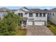 Two-story house with gray exterior, three-car garage, and a paved driveway at 1402 Olympic Club Blvd, Champions Gate, FL 33896