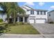 Two-story house with gray exterior, three-car garage, and a paved driveway at 1402 Olympic Club Blvd, Champions Gate, FL 33896