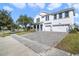 Two-story house with a three-car garage and paver driveway at 1402 Olympic Club Blvd, Champions Gate, FL 33896
