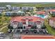 Well-maintained condo building showcasing lush landscaping, ample parking, and a vibrant red tile roof at 445 Bouchelle Dr # 202, New Smyrna Beach, FL 32169