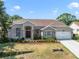 Charming home featuring a brick and stucco facade, manicured landscaping, and a two-car garage at 2226 Lake Marion Dr, Apopka, FL 32712