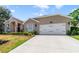 Well-maintained home exterior showcasing a spacious driveway and a two-car garage with an attached brick-accented facade at 2226 Lake Marion Dr, Apopka, FL 32712