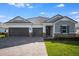 Charming single-story home boasts a three-car garage, paver driveway and stone accents at 2956 Arranmore Dr, Ormond Beach, FL 32174